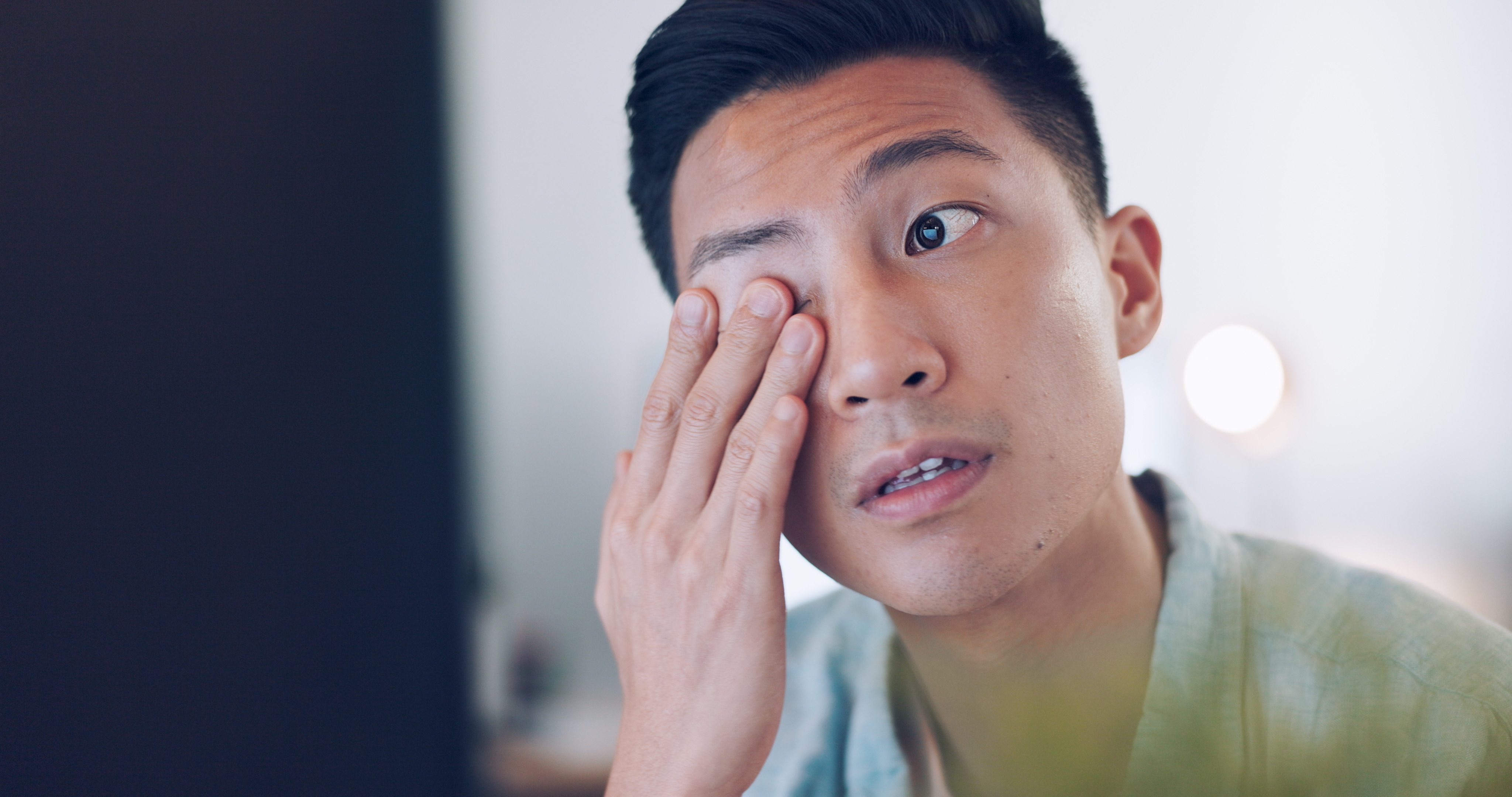 Un homme asiatique qui se frotte les yeux